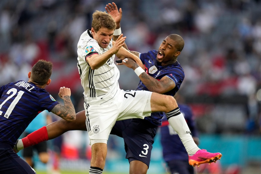 Thomas Mueller and Presnel Kimpembe both grimace as the collide in the air