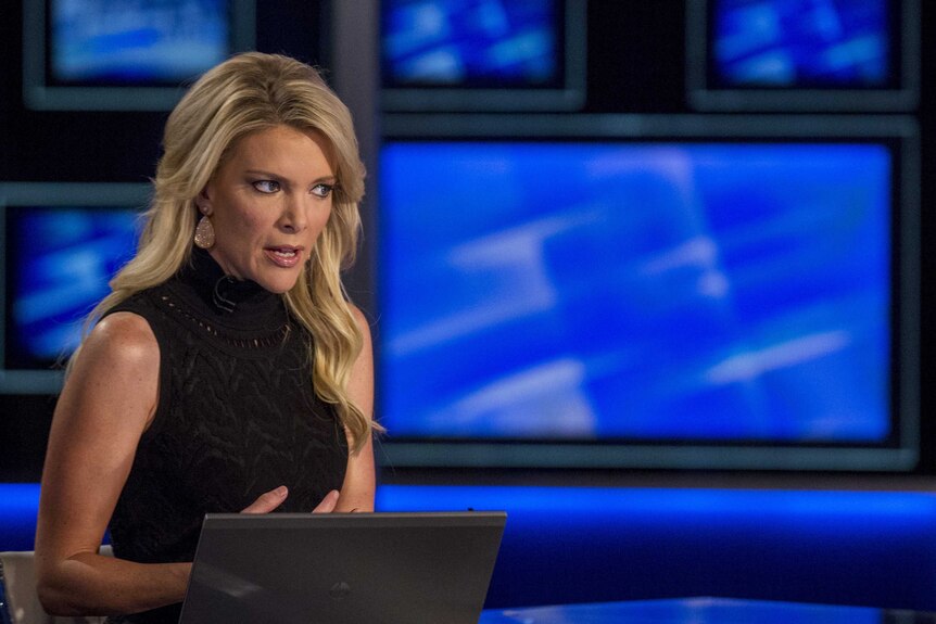 Fox News Host Megyn Kelly looks concerned, sitting at a news desk,as she prepares for her Fox News Channel show