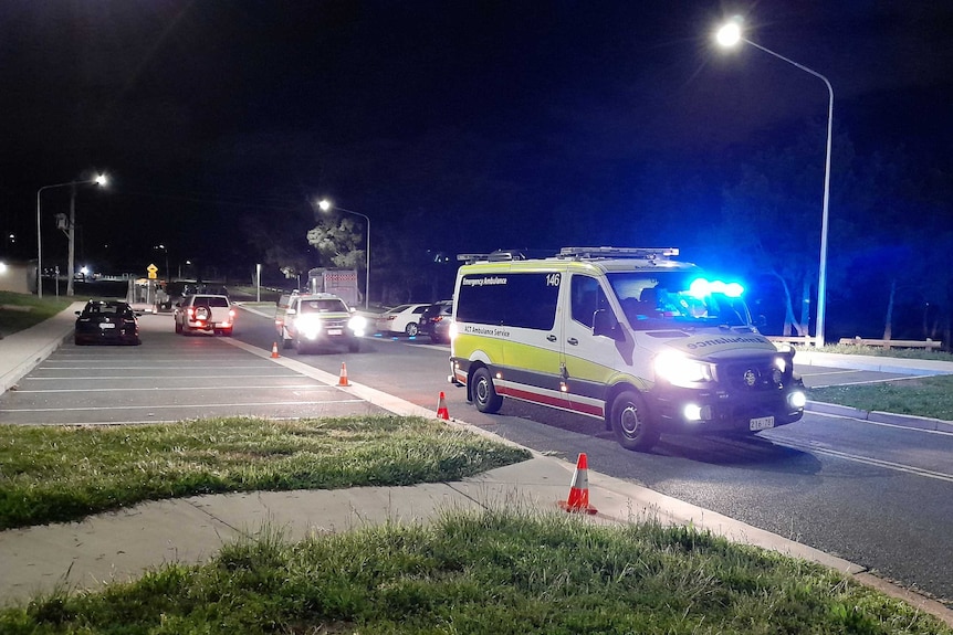 An ambulance with its lights on at night.