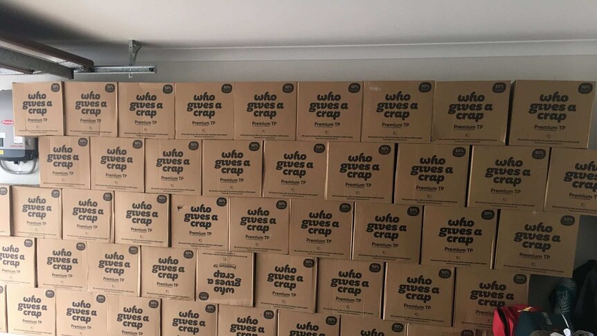Wall of boxes containing toilet paper rolls in a garage