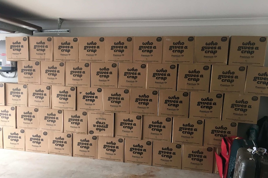 Wall of boxes containing toilet paper rolls in a garage