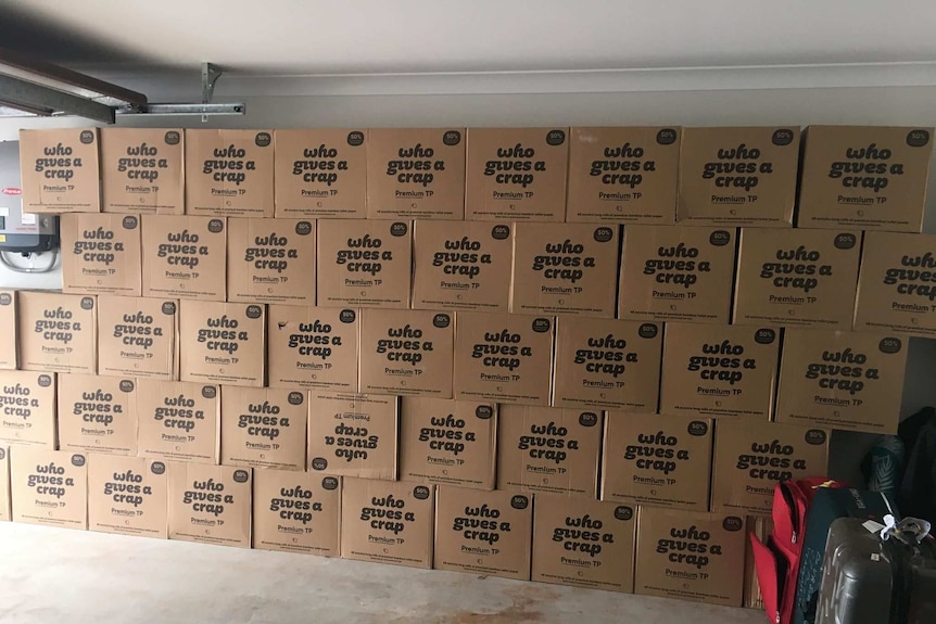 Wall of boxes containing toilet paper rolls.