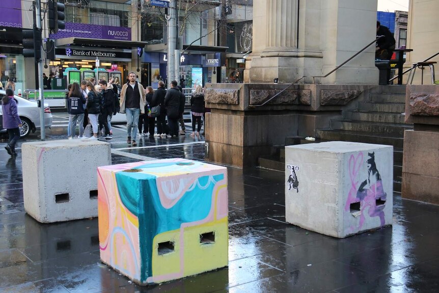 Concrete security bollards in Bourke Street mall painted by street artists.