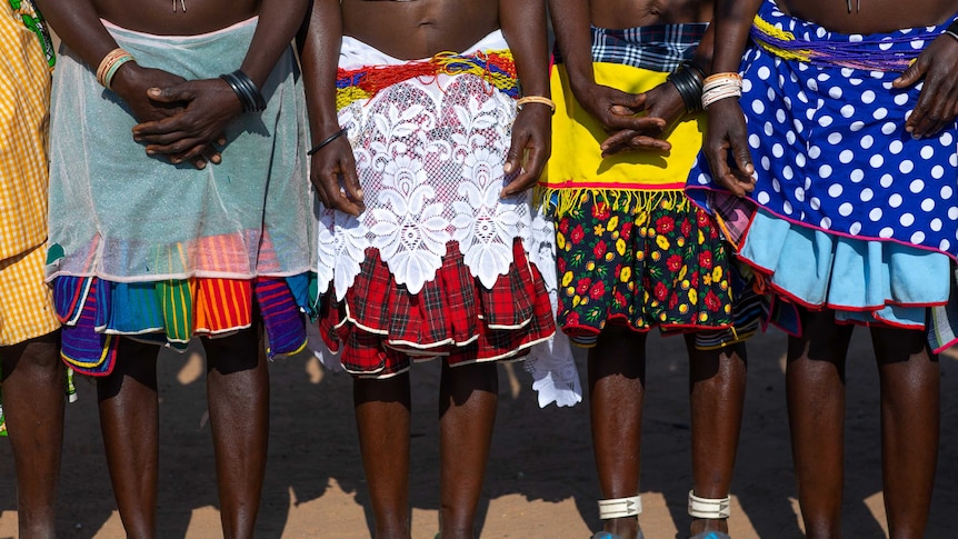 A shot of the legs of Mudimba tribe women from Angola wearing colourful, traditional clothing.