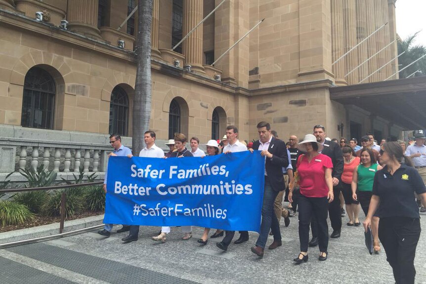More than 100 people march through Brisbane against family violence.