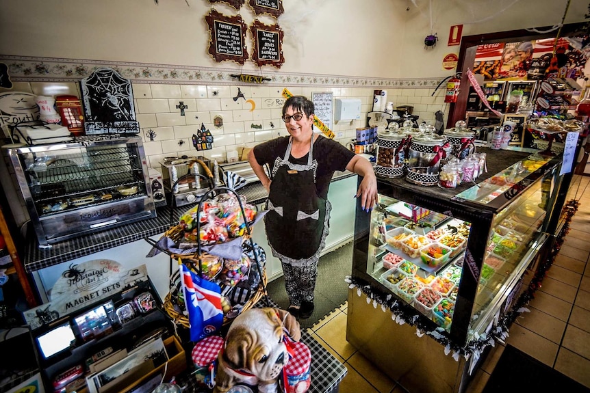 Woman stands behind the counter of a milk bar