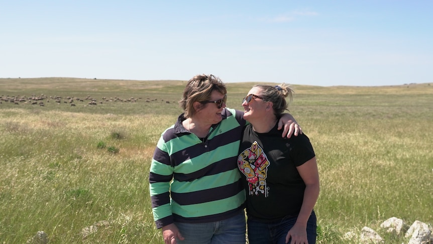 Two women hug and smile at each other