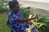 Betty Tekahika weaves coconut fronds
