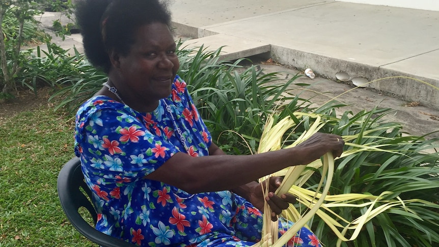 Betty Tekahika weaves coconut fronds