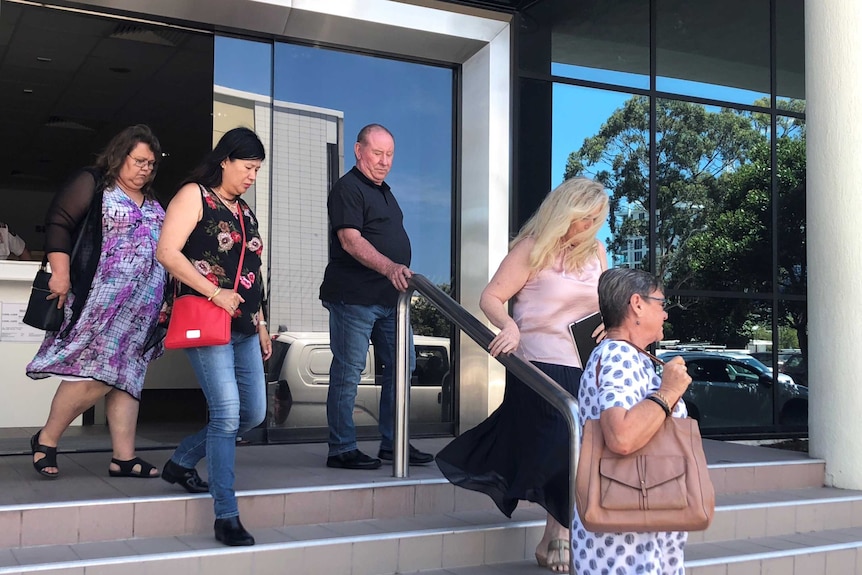 Family members walk down the court stairs.