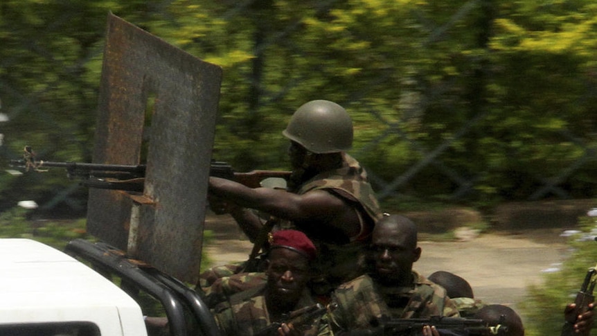 Pro-Gbagbo militia men ride in a pick-up truck