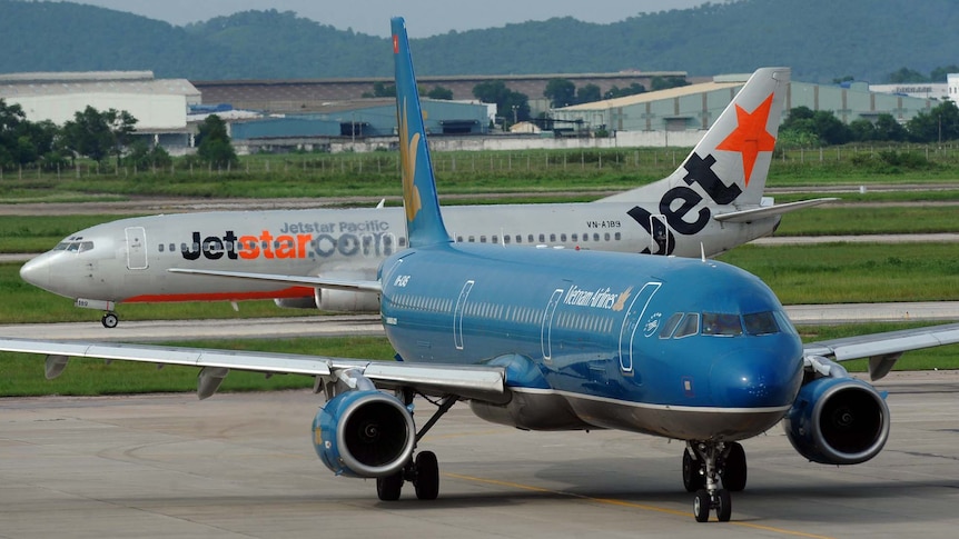 A Vietnam Airlines aircraft taxies next to a Jetstar Pacific aircraft