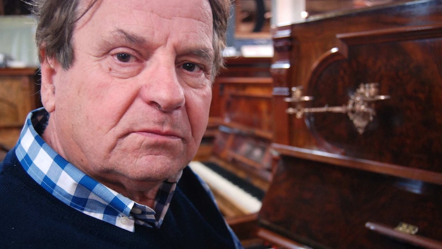 Eric Hawkes sitting in his North Hobart piano restoration workshop.