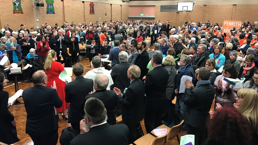 A crowd of people in a school hall.