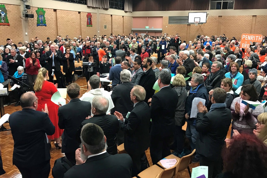 A crowd of people in a school hall.