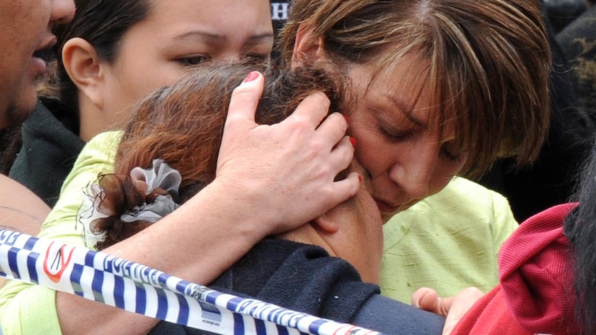 Anna Bligh hugs the sister of a house fire victim at the scene in Kingston