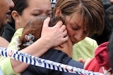 Anna Bligh hugs the sister of a house fire victim at the scene in Kingston