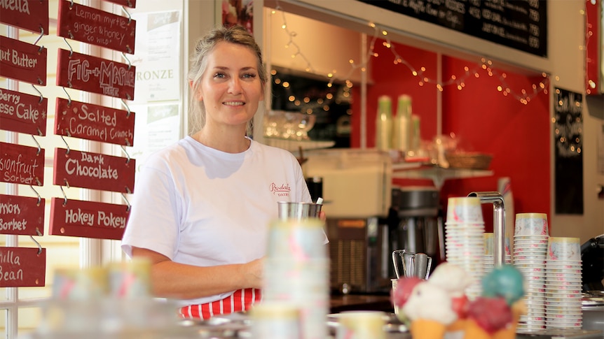 Celeste McGrath holds a milkshake glass behind the counter at the Bodalla Dairy Shed.