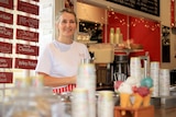 Celeste McGrath holds a milkshake glass behind the counter at the Bodalla Dairy Shed.
