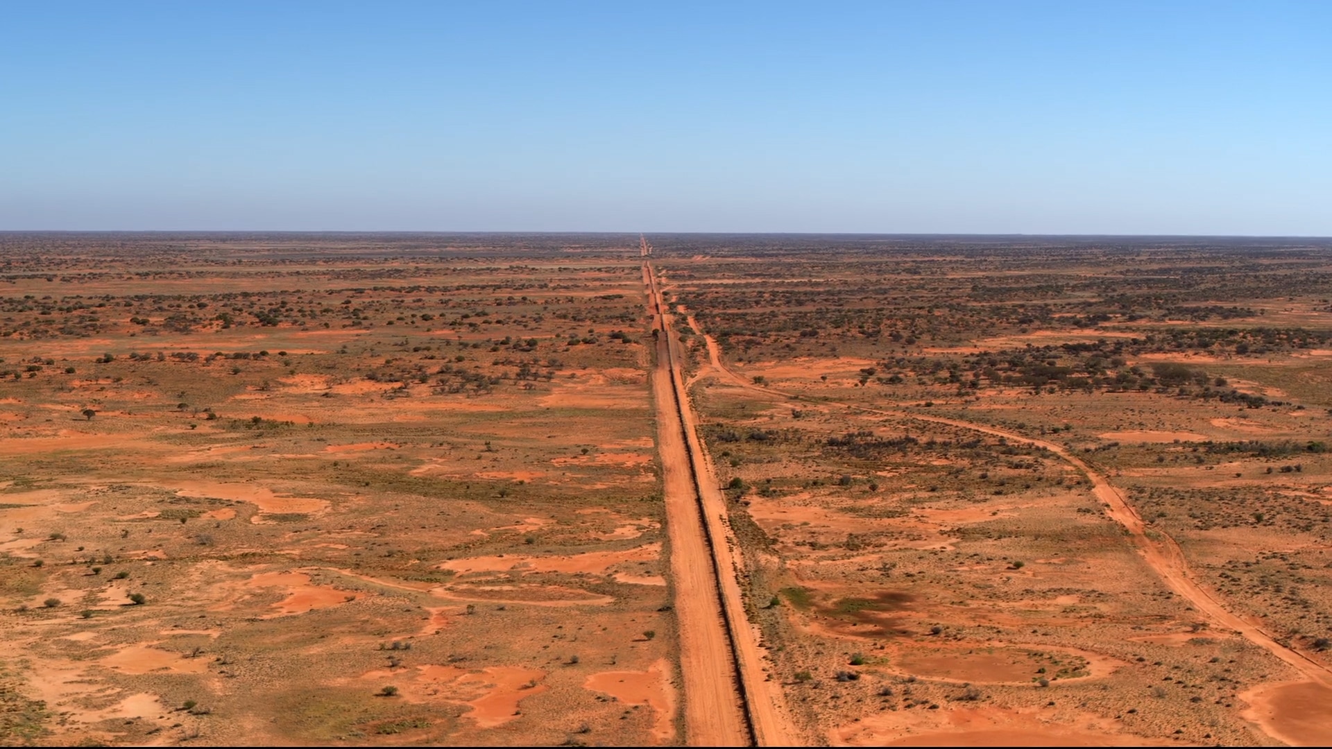A fence in the outback disappearing into the horizon