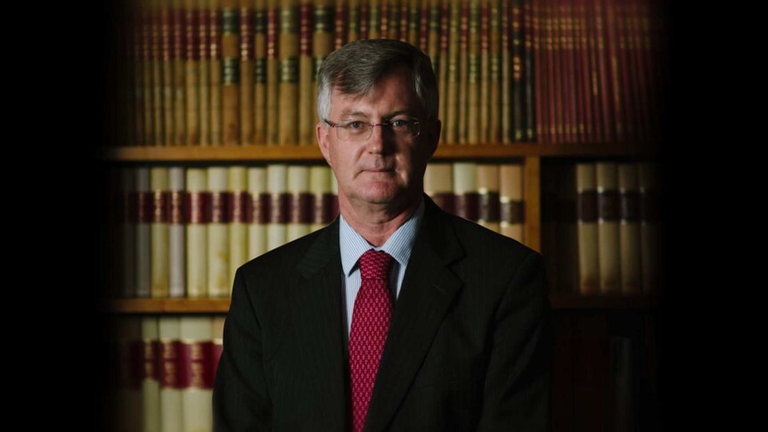 Martin Parkinson stands in front of a bookshelf.