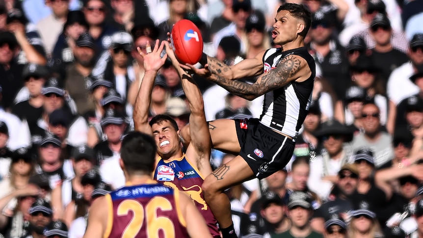 A Collingwood AFL player takes a mark during the grand final against the Brisbane Lions.