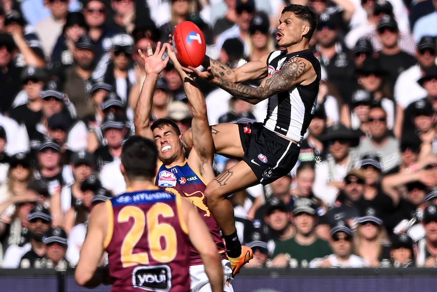 A Collingwood AFL player takes a mark during the grand final against the Brisbane Lions.