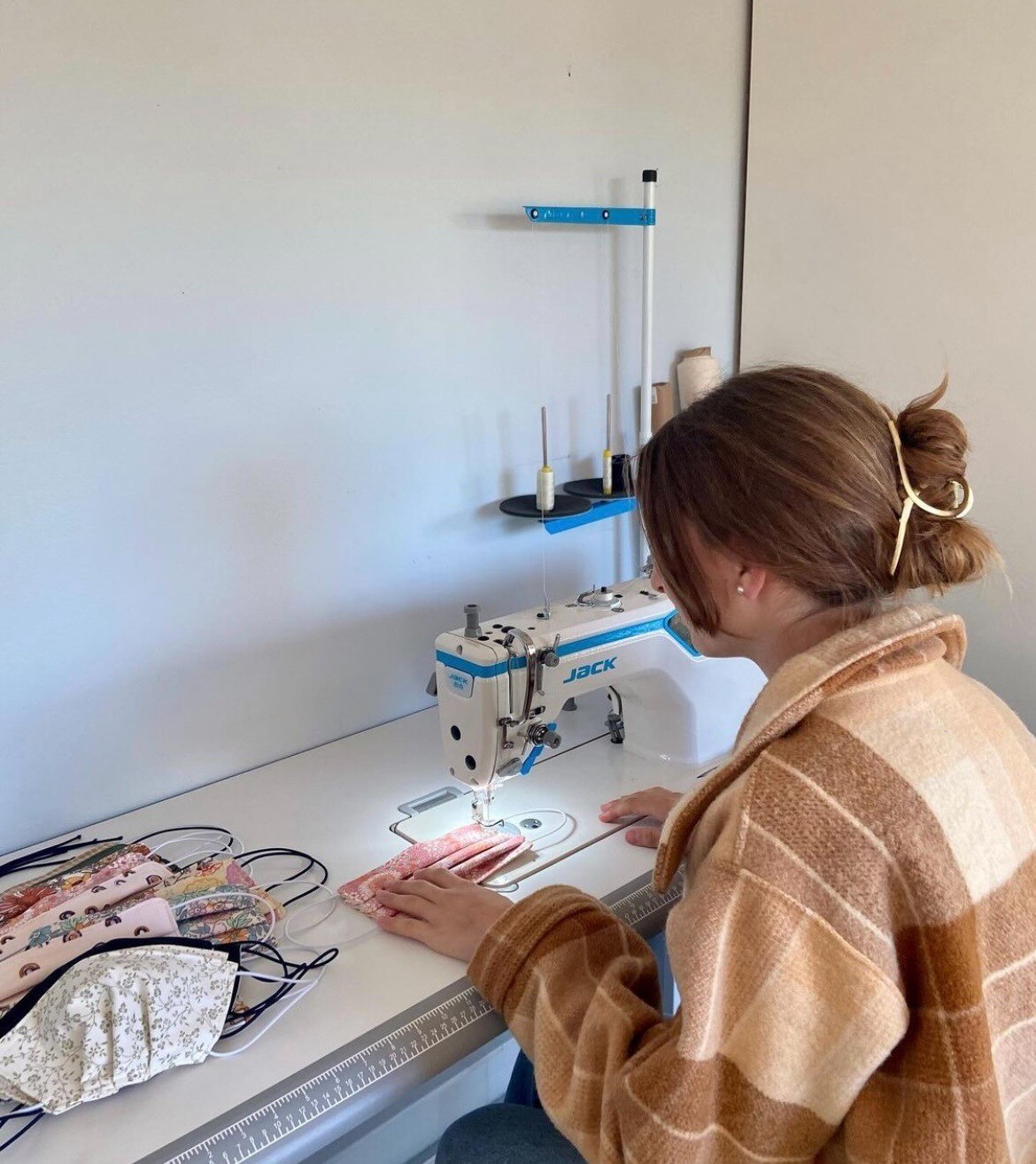 Monique sitting at her desk sewing.