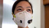 A woman wearing an N95 face mask with small attached sensors