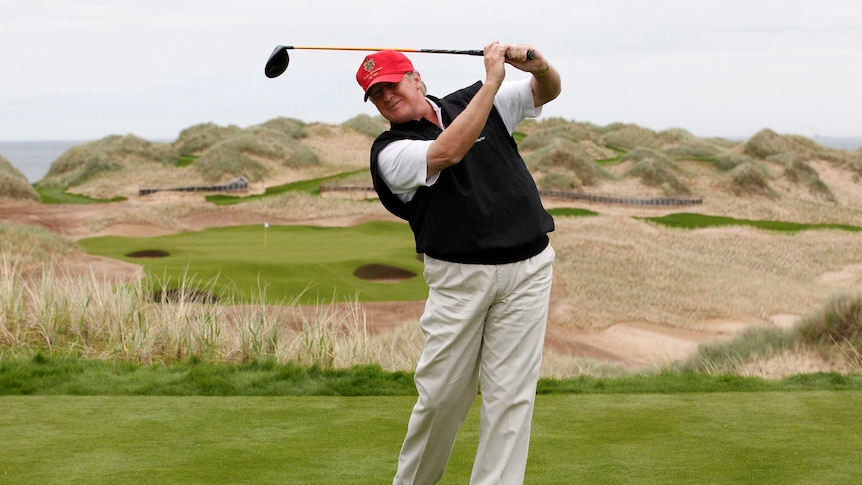 Donald Trump practices his golf swing at a course in Scotland.