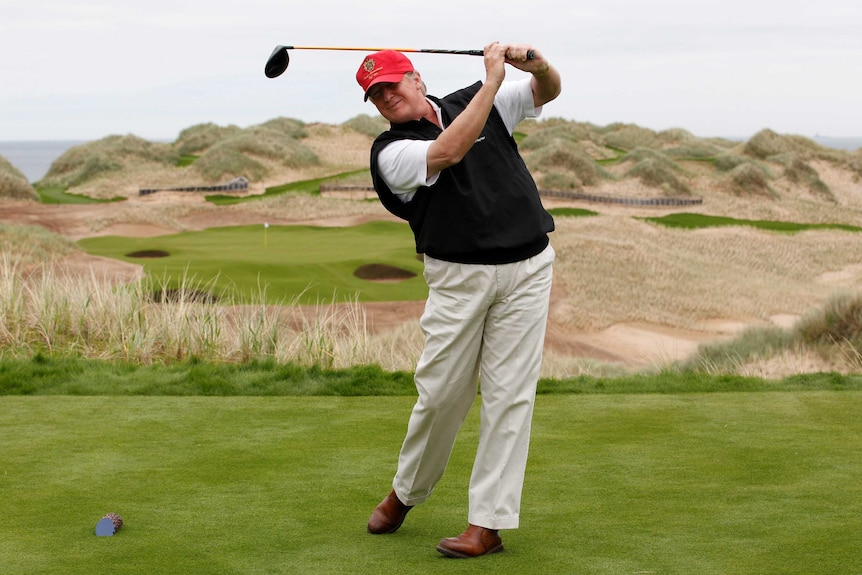 Donald Trump practices his golf swing at a course in Scotland.