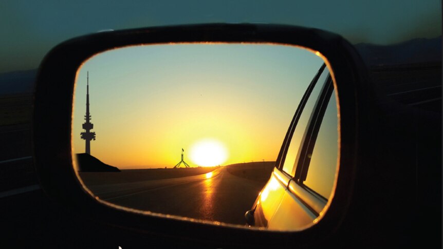 Image of Canberra landscape by sunset in car side mirror with text 'Regeneration Roadtrip'