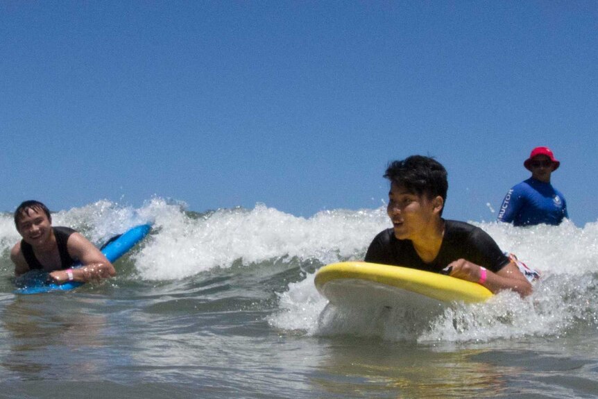 Two boys catch a wave on Henley Beach.