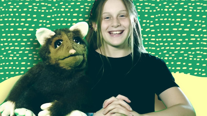 Tiyana smiling with a puppet next to her.