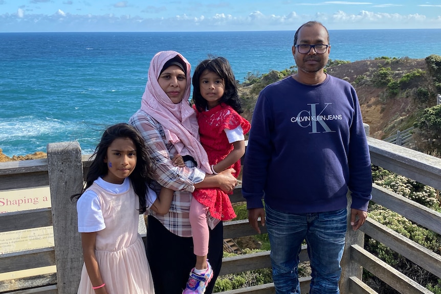 A man at the beach with his family.