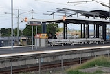 Wide generic shot of Woodridge train station platform at tracks.