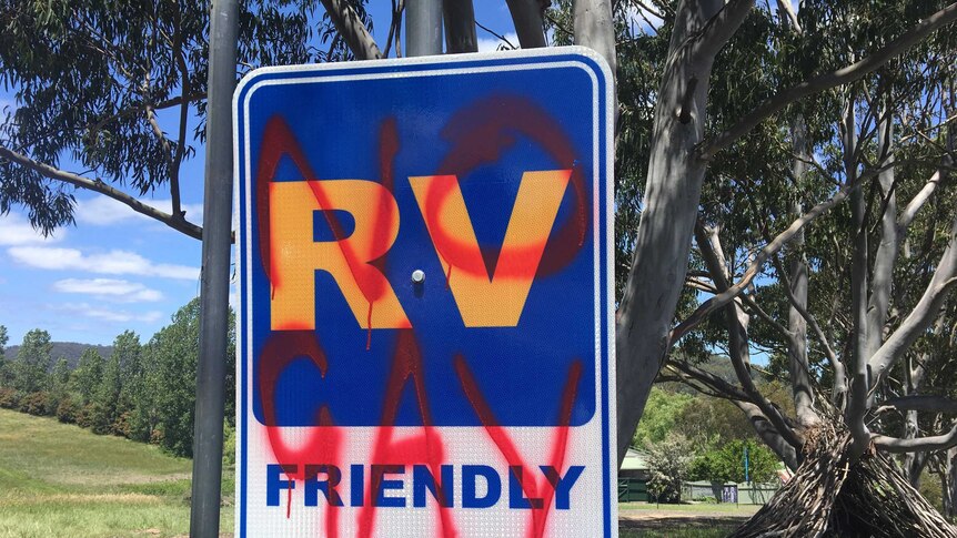 "No gay" spray painted in red over a street sign welcoming campervans to Cobargo