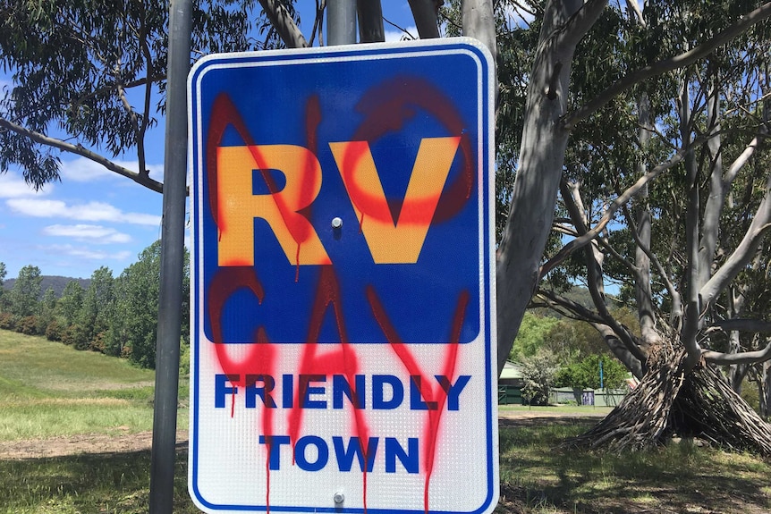 "No gay" spray painted in red over a street sign welcoming campervans to Cobargo