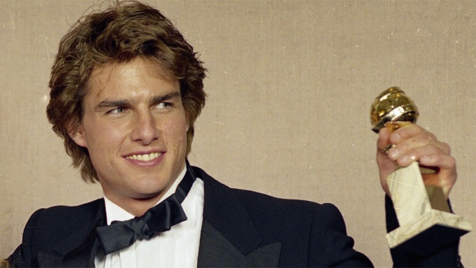 A young Tom Cruise holds a golden globe award