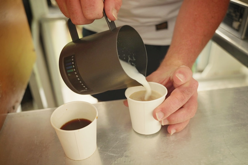 Close-up of Bobby Pate making two coffees in his refurbished kombi barista van.