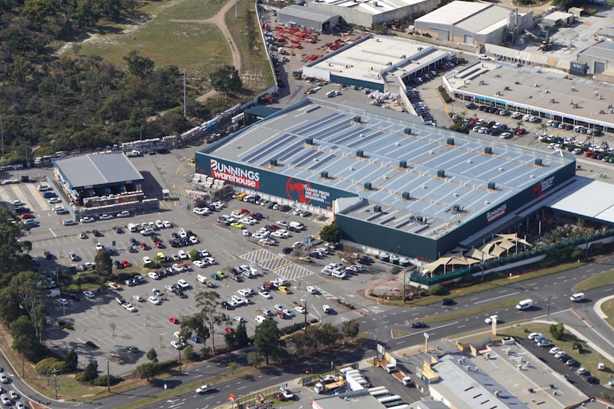 An aerial shot of a Bunnings store in Perth, showing cars and bushland nearby