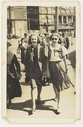 A black and white photograph of two women on the street.