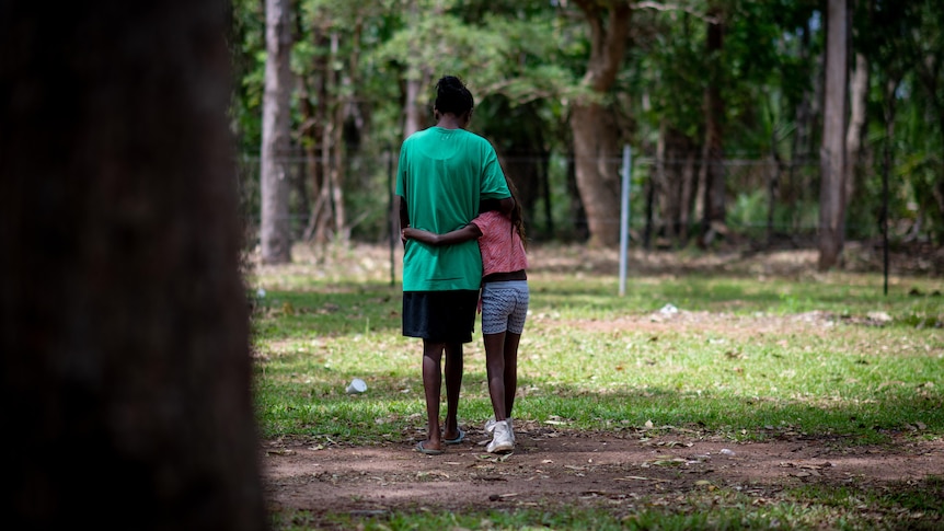 two young people hug in woodlands