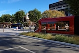 An artist's impression shows a light rail vehicle stopped at a traffic light in Woden.