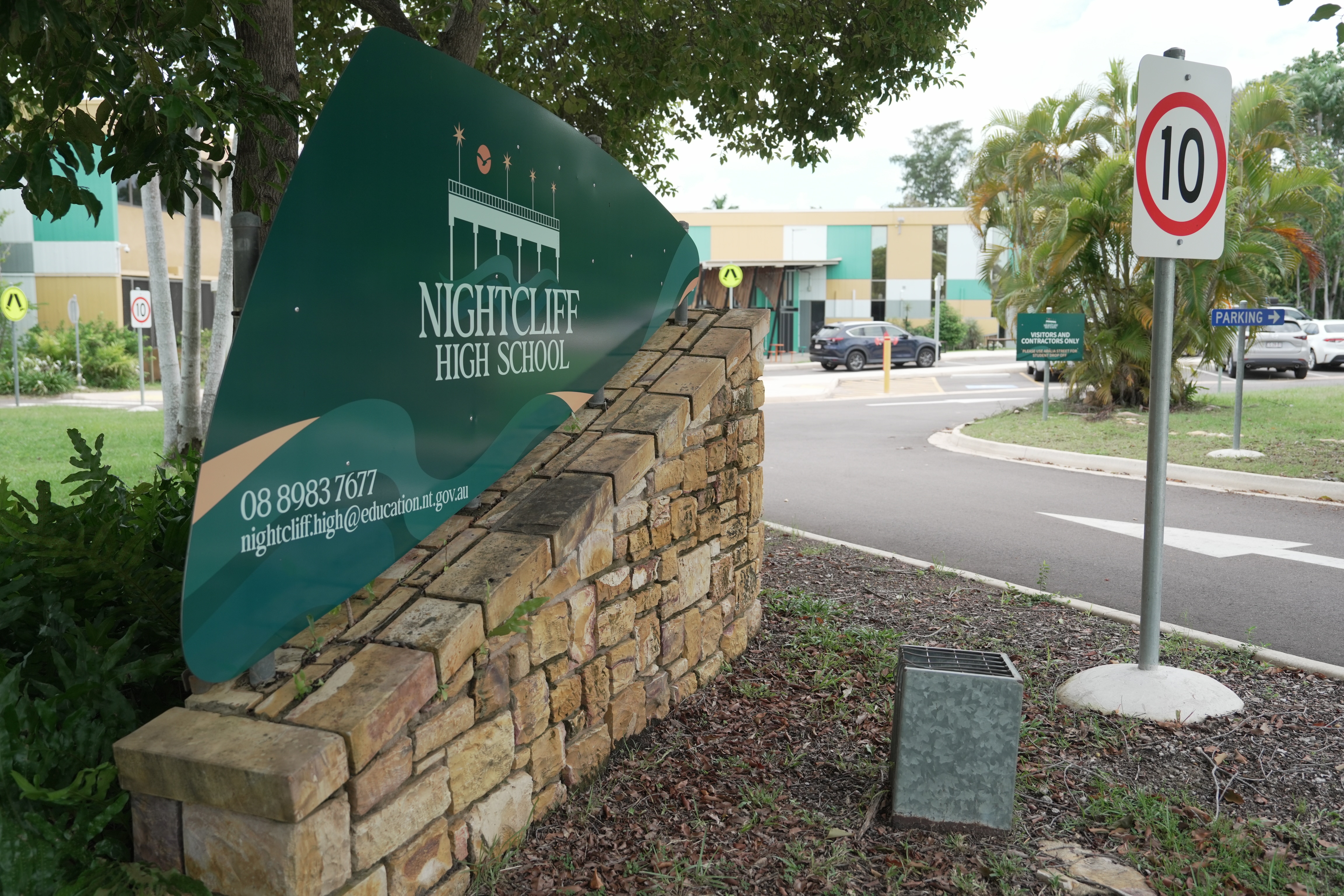A imagem de uma placa que diz Nightcliff High School na entrada da escola.