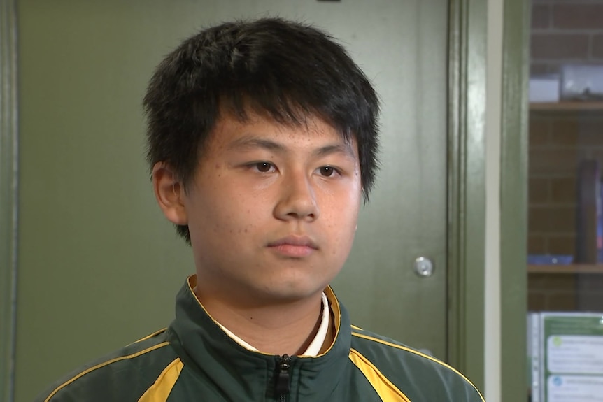 a young student sitting down looking