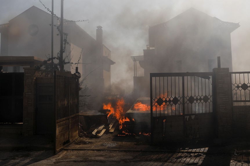 Un'auto ha preso fuoco tra due case coperte di fumo. 