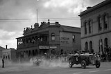 Old photo of race cars in town