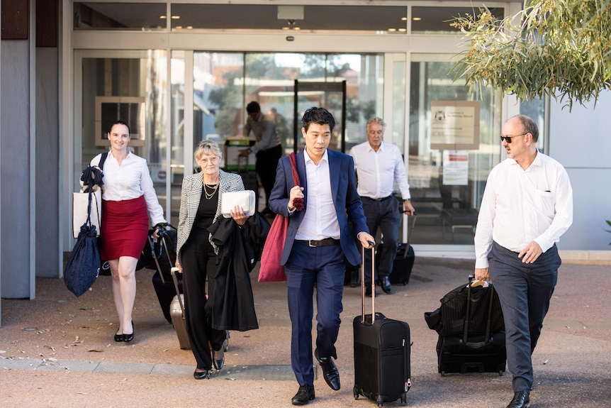 Five lawyers leaving courthouse with briefcases