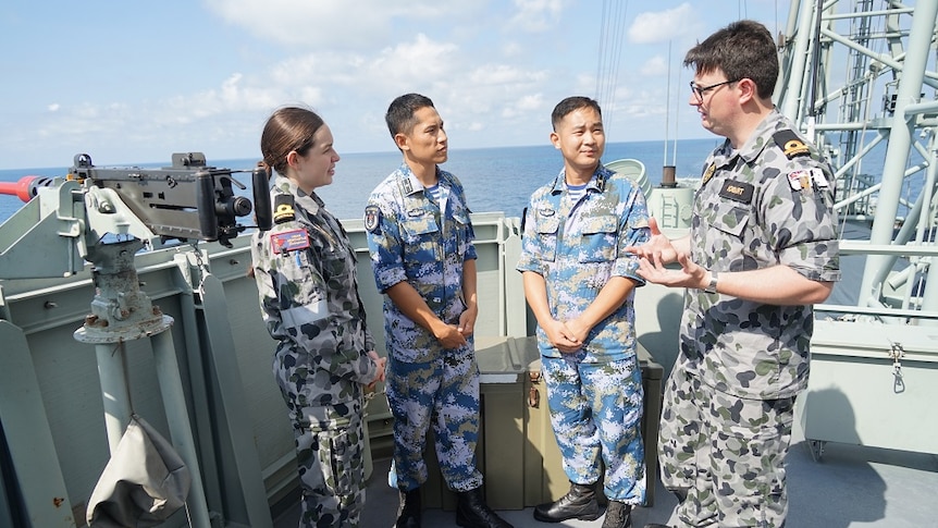 Australian sailors speak to People’s Liberation Army-Navy sailors on board HMAS Newcastle.